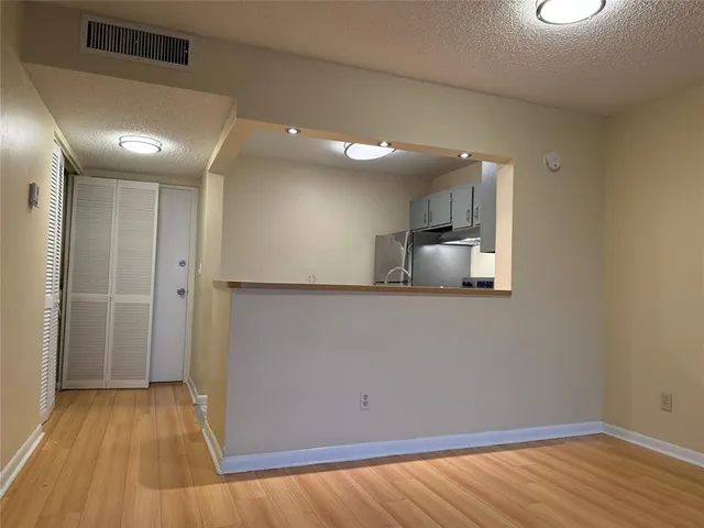 a view of a kitchen with a sink and wooden floor