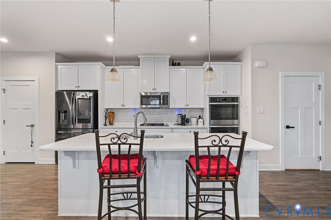 1605 German School Road Richmond, VA 23225 - Photo 7 of 27 a kitchen with stainless steel appliances kitchen island granite countertop a refrigerator a stove top oven a sink dishwasher and white cabinets with wooden floor