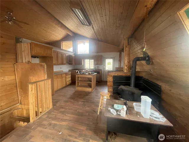 a living room with stainless steel appliances furniture a rug and a kitchen view