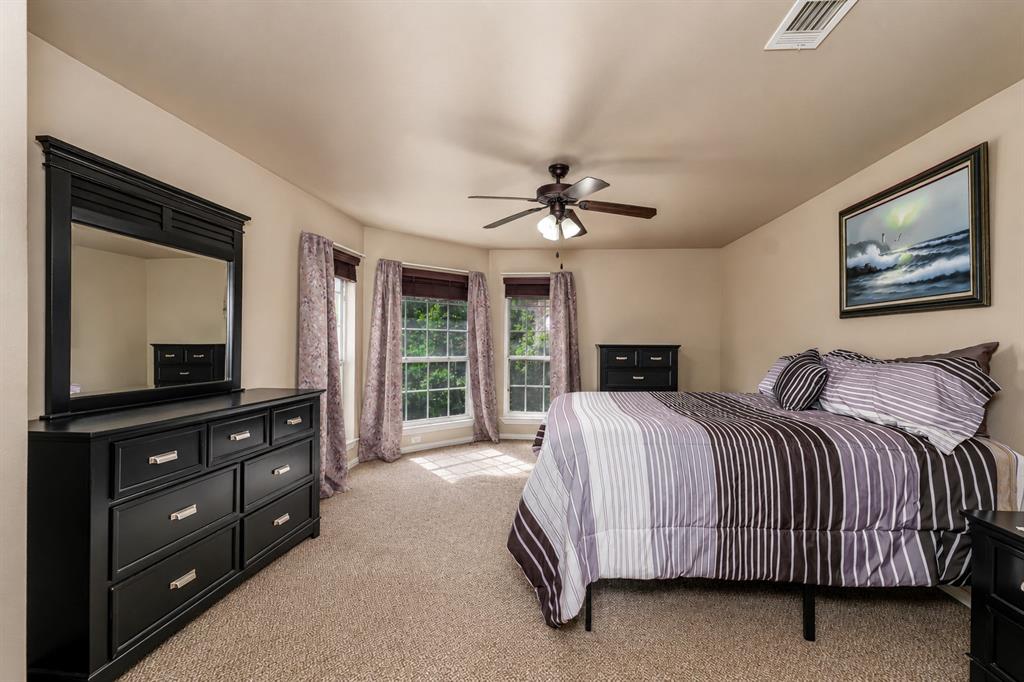 100 Manders Court Runaway Bay, TX 76426 - Photo 29 of 33 a bedroom with a bed and a flat tv screen on dresser