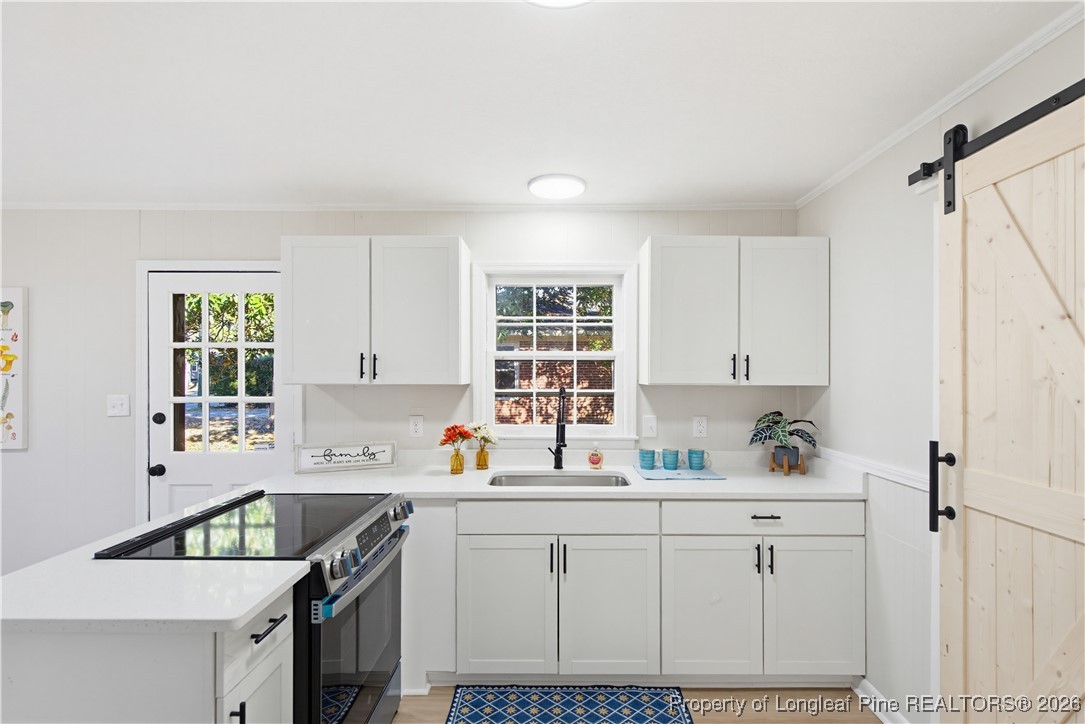 425 Ralph Street Fayetteville, NC 28301 - Photo 13 of 36 a kitchen with cabinets appliances a sink and a window