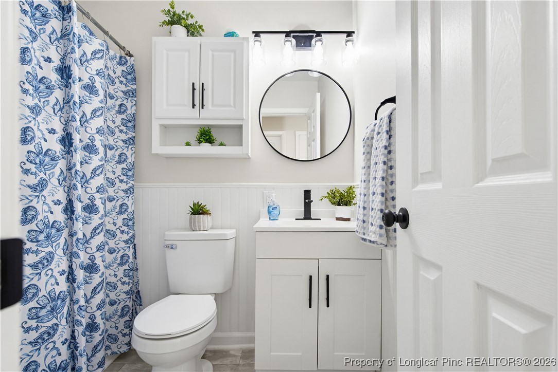 425 Ralph Street Fayetteville, NC 28301 - Photo 23 of 36 a bathroom with a toilet sink vanity granite and a mirror