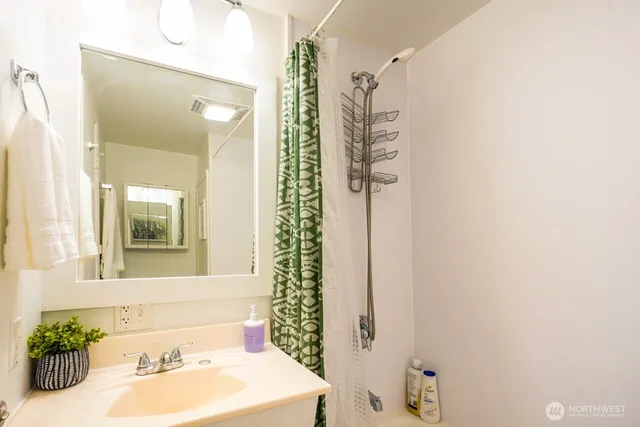 a bathroom with a sink a mirror and a shower