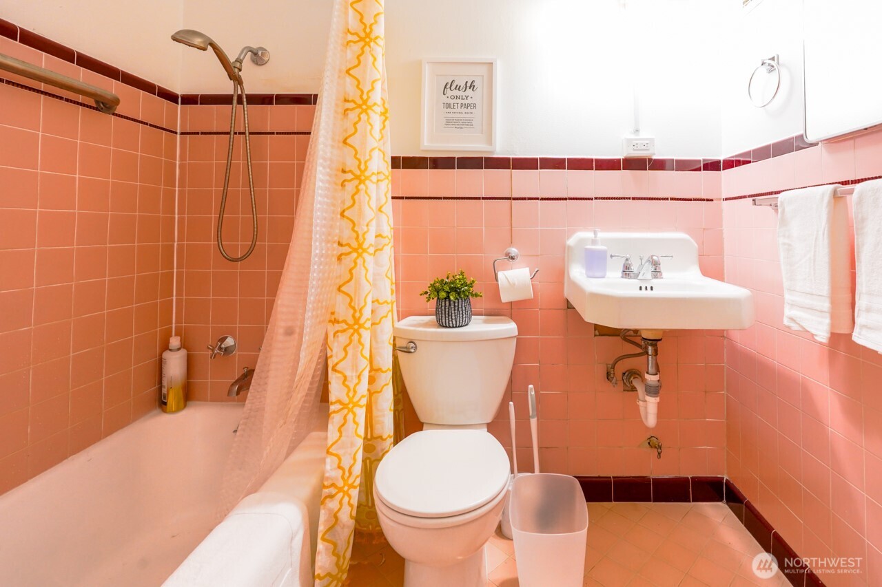 4027 Beach Drive Southwest, Unit 2 Seattle, WA 98116 - Photo 22 of 30 a bathroom with a sink a toilet and a mirror