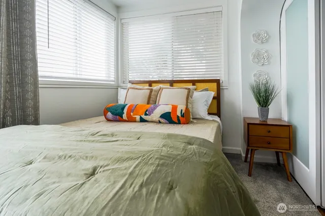a bed sitting in a bedroom next to a window