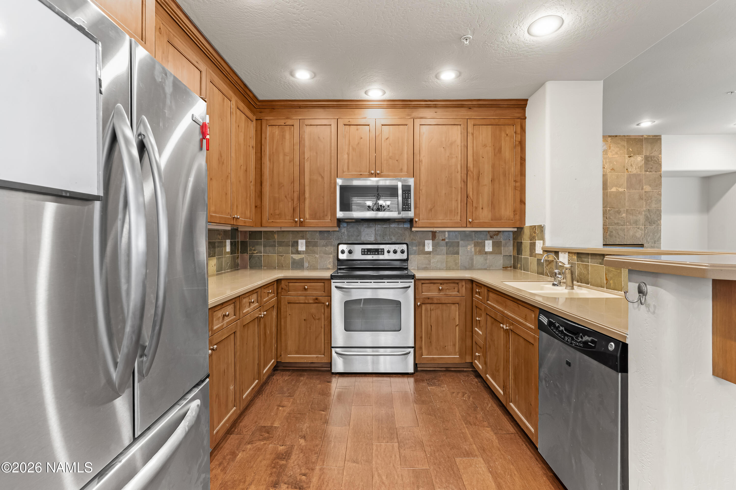 4860 West Quick Draw Flagstaff, AZ 86005 - Photo 7 of 32 a kitchen with stainless steel appliances granite countertop a refrigerator a stove and a sink