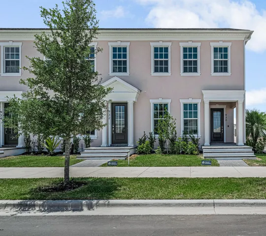 a front view of a house with plants