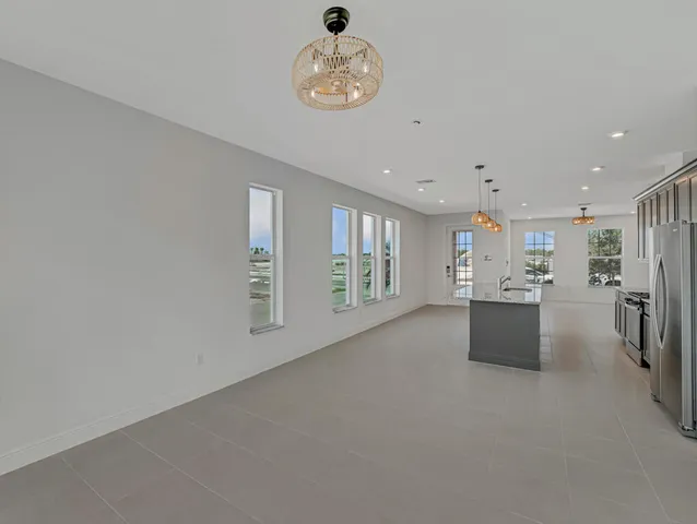 a kitchen with kitchen island granite countertop stainless steel appliances a stove cabinets a sink and a refrigerator