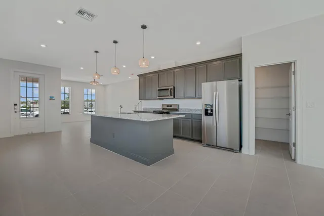 a kitchen with granite countertop white cabinets stainless steel appliances and a sink