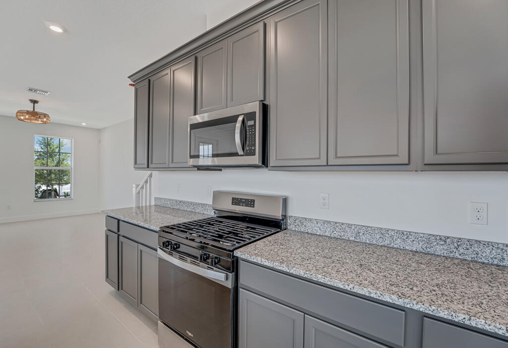 930 Southwest Pr Avenue Palm City, FL 34990 - Photo 14 of 66 a kitchen with granite countertop white cabinets stainless steel appliances and a sink