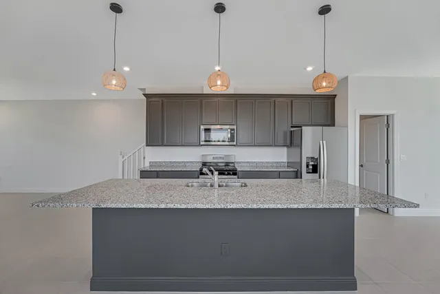 a kitchen with stainless steel appliances granite countertop a stove a sink and a refrigerator