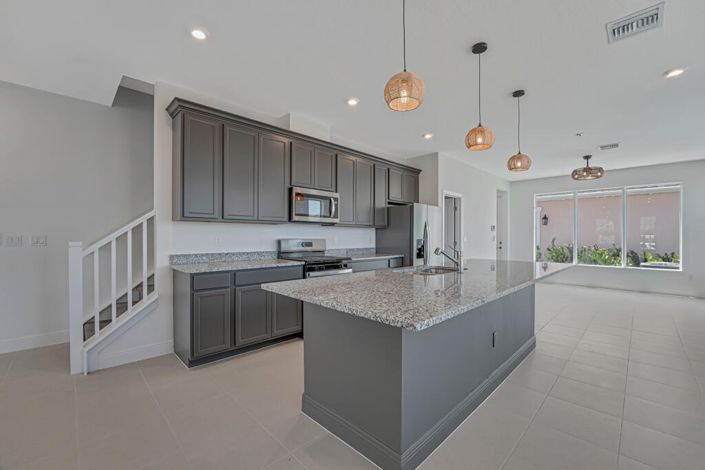 930 Southwest Pr Avenue Palm City, FL 34990 - Photo 16 of 66 a kitchen with stainless steel appliances granite countertop a sink stove and cabinets