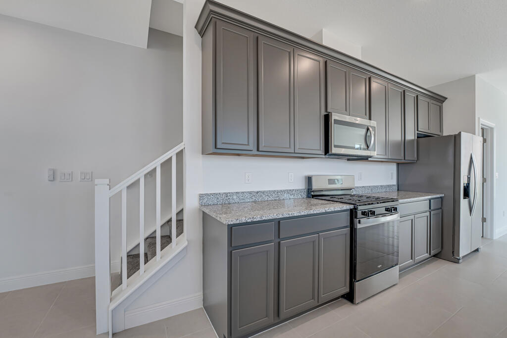 930 Southwest Pr Avenue Palm City, FL 34990 - Photo 17 of 66 a kitchen with stainless steel appliances granite countertop a stove a sink and a refrigerator