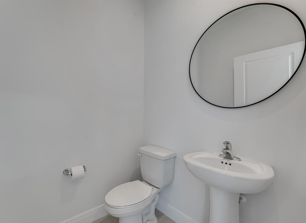 930 Southwest Pr Avenue Palm City, FL 34990 - Photo 19 of 66 a bathroom with a sink a toilet and a mirror