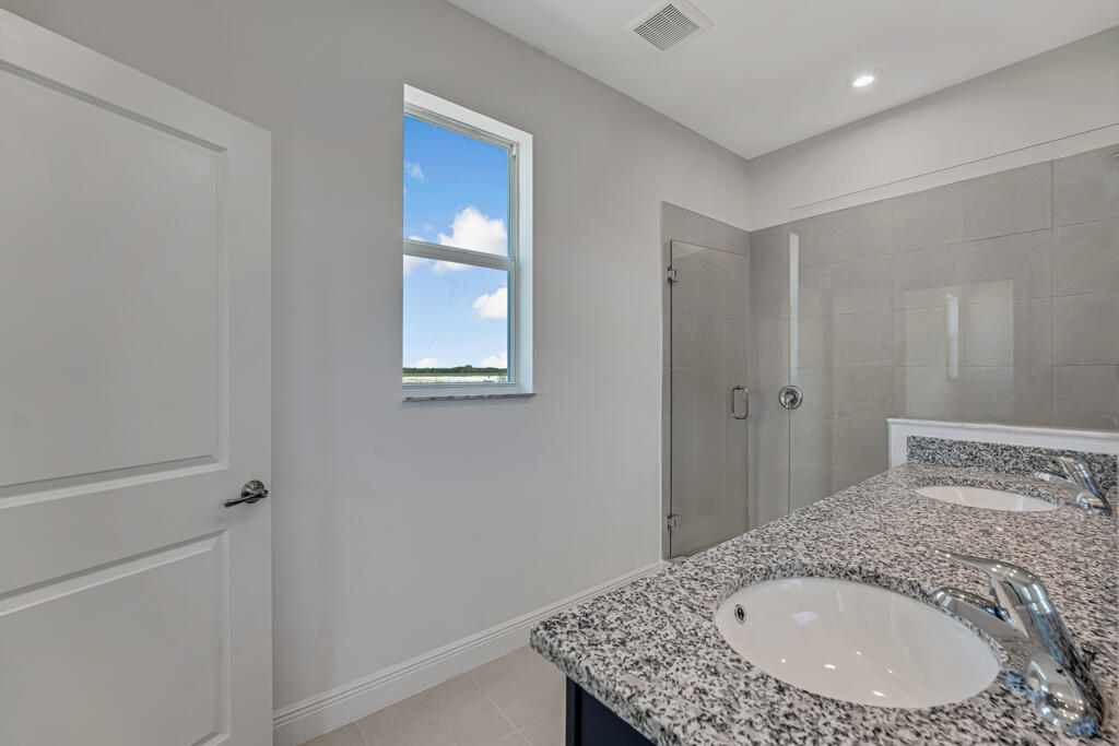 930 Southwest Pr Avenue Palm City, FL 34990 - Photo 26 of 66 a en suite bathroom with a granite countertop sink and a mirror