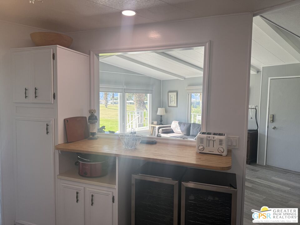 15500 Bubbling Wells Road, Unit 286 Desert Hot Springs, CA 92240 - Photo 11 of 50 a kitchen with kitchen island granite countertop a sink cabinets and wooden floor