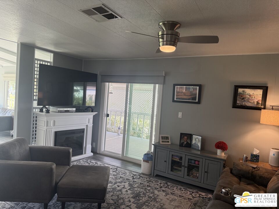 15500 Bubbling Wells Road, Unit 286 Desert Hot Springs, CA 92240 - Photo 15 of 50 a living room with furniture a flat screen tv and a fireplace