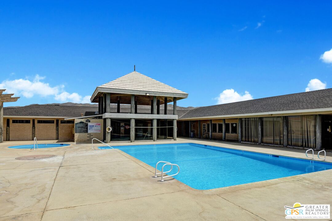 15500 Bubbling Wells Road, Unit 286 Desert Hot Springs, CA 92240 - Photo 31 of 50 a view of a house with large trees and wooden fence