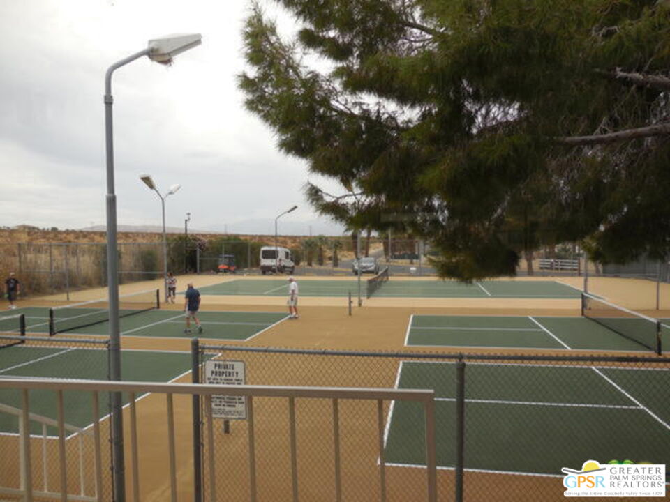 15500 Bubbling Wells Road, Unit 286 Desert Hot Springs, CA 92240 - Photo 46 of 50 a view of a tennis court with buildings in the background