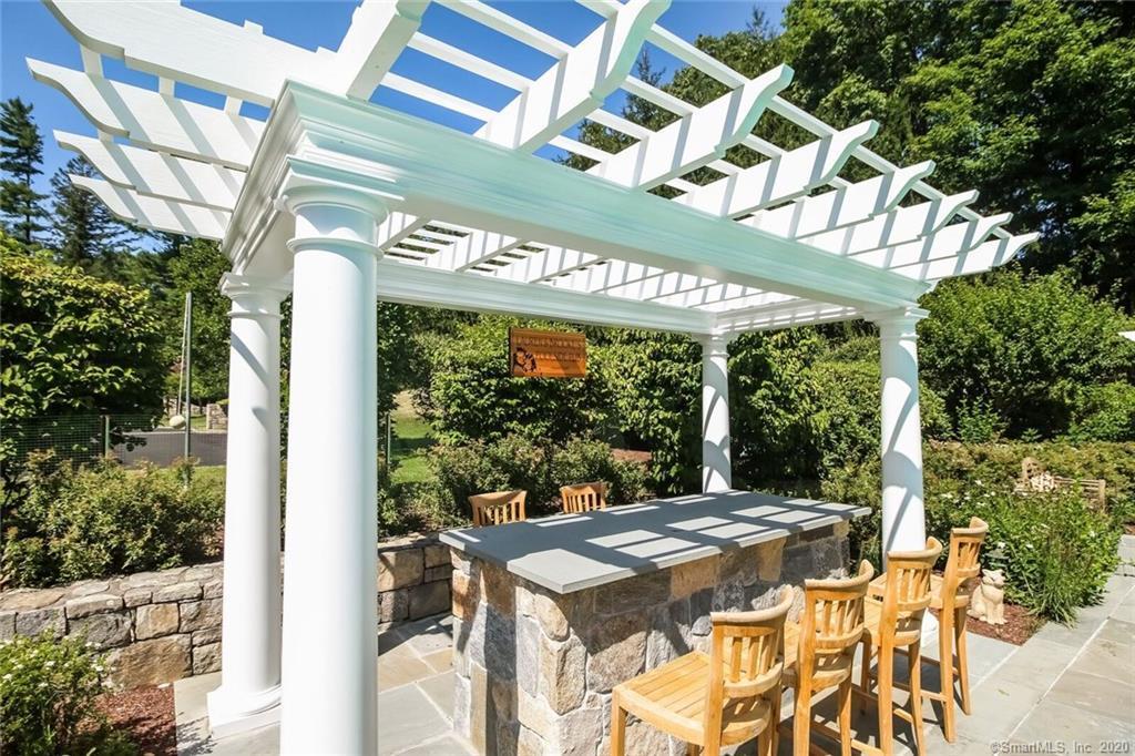 83 Lukes Wood Road New Canaan, CT 06840 - Photo 47 of 51 a view of a patio with a table and chairs