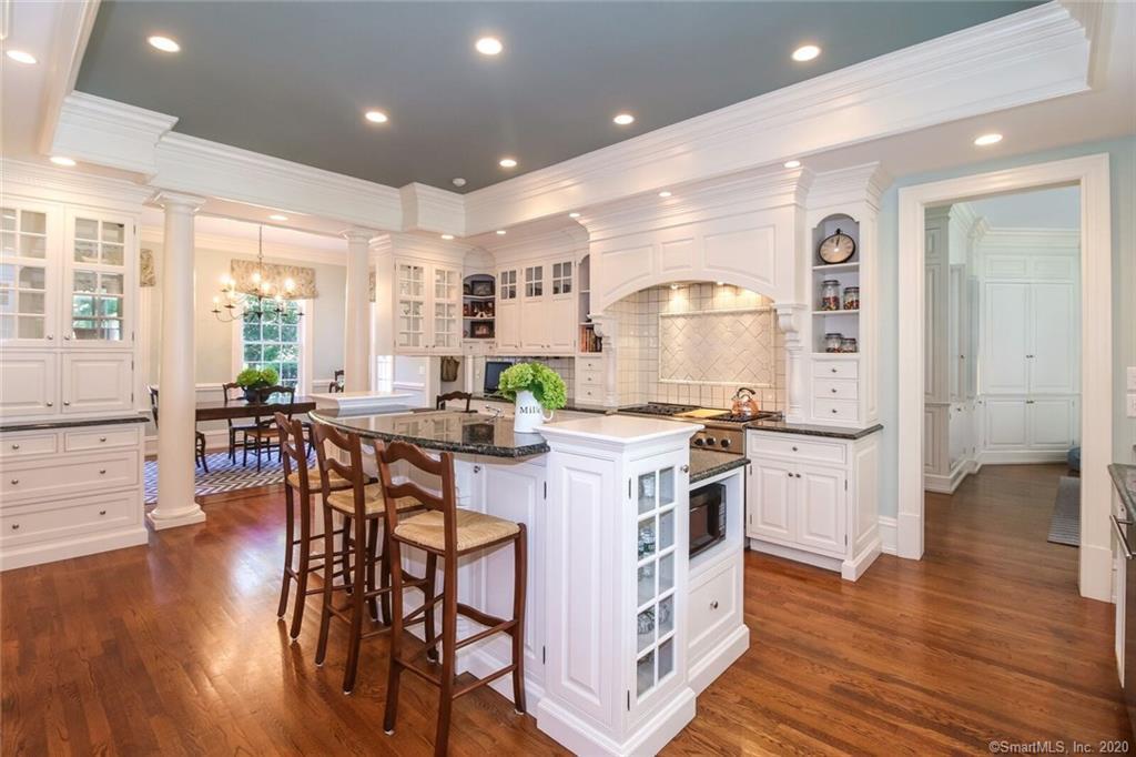 83 Lukes Wood Road New Canaan, CT 06840 - Photo 7 of 51 a kitchen with stainless steel appliances a dining table chairs stove and wooden floor