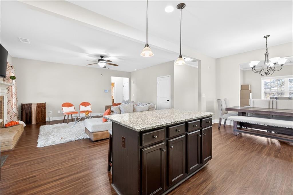 860 Tranquil Way Hampton, GA 30228 - Photo 13 of 54 a kitchen with a stove center island wooden floor and living room view