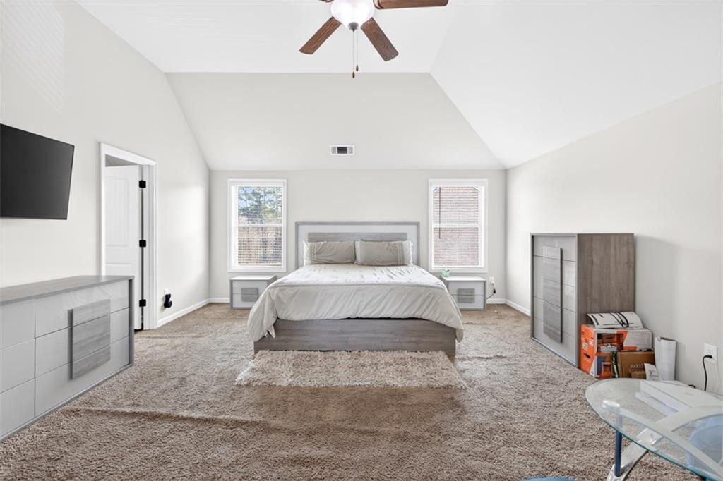 860 Tranquil Way Hampton, GA 30228 - Photo 24 of 54 a bedroom with a large bed and a flat tv screen on dresser