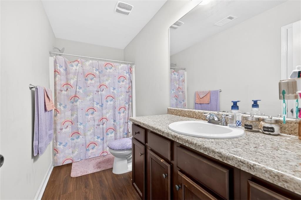 860 Tranquil Way Hampton, GA 30228 - Photo 37 of 54 a bathroom with a granite countertop sink toilet and a mirror