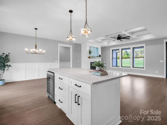 a view of a kitchen with granite countertop natural light and white cabinets