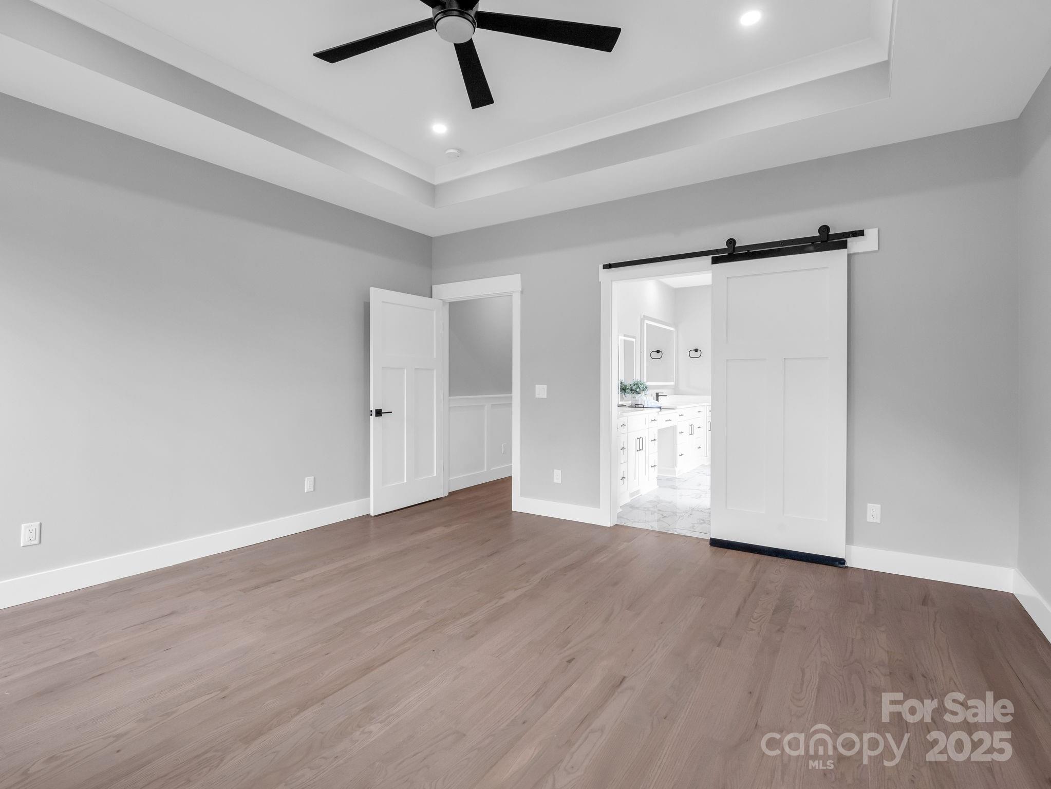 128 Gravely Branch Road Fletcher, NC 28732 - Photo 18 of 48 a view of an empty room with wooden floor and a ceiling fan