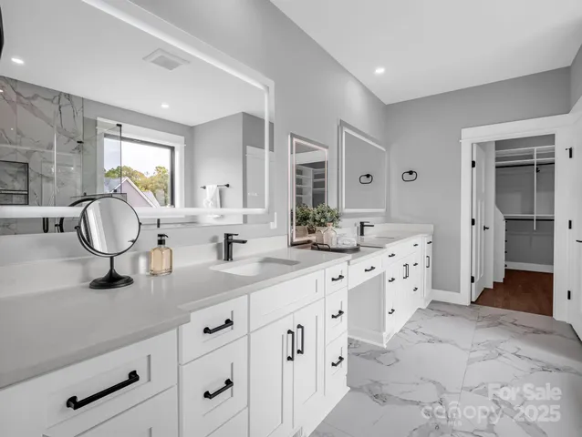 a spacious bathroom with a double vanity sink mirror and a shower