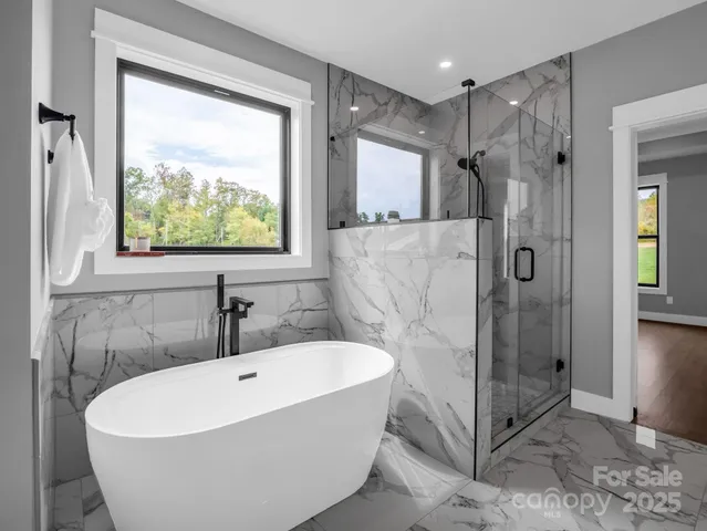a white bath tub sitting next to a shower