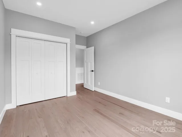 an empty room with wooden floor and closet