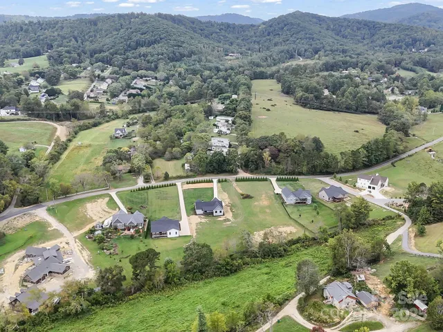 an aerial view of residential houses with outdoor space and pool