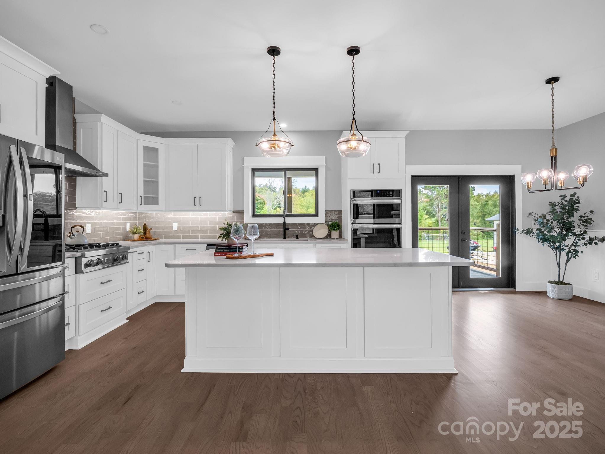 128 Gravely Branch Road Fletcher, NC 28732 - Photo 6 of 48 a kitchen with stainless steel appliances granite countertop a stove a sink dishwasher a refrigerator and a dining table with wooden floor