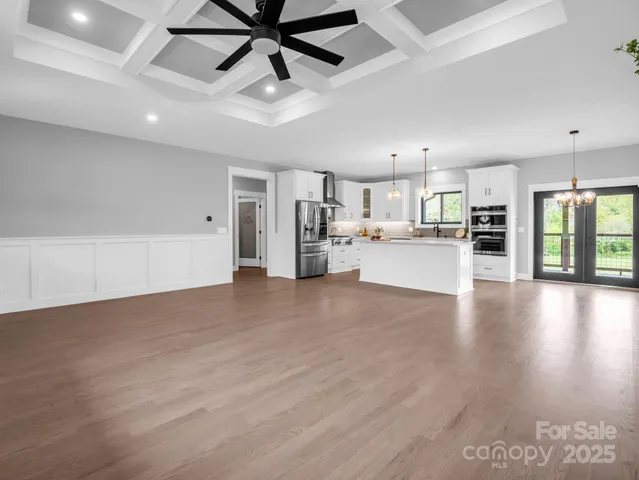 a view of a kitchen with a refrigerator wooden floor and a kitchen