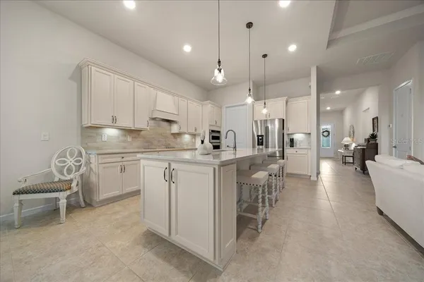 a view of a kitchen with kitchen island a sink and a refrigerator