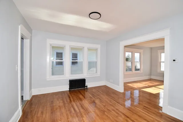 a view of empty room with wooden floor and fireplace