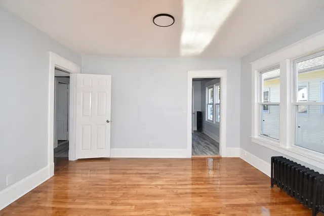 a view of empty room with wooden floor