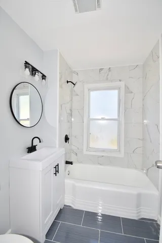 a bathroom with a bathtub a sink and a mirror