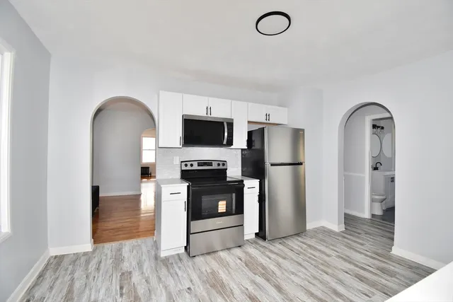 a kitchen with stainless steel appliances kitchen island granite countertop a refrigerator stove and sink