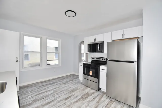 a kitchen with stainless steel appliances a refrigerator sink and microwave