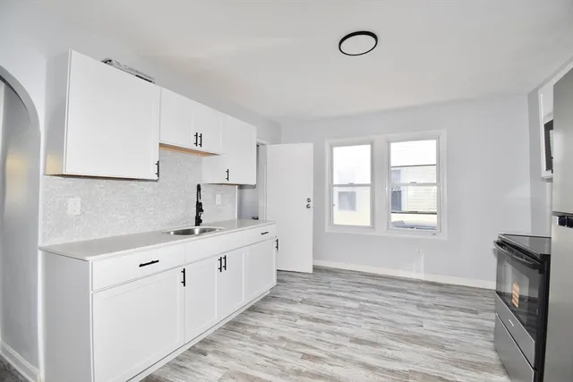 a kitchen with cabinets a sink and a window
