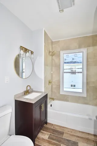 a bathroom with a toilet a sink a mirror and a bathtub