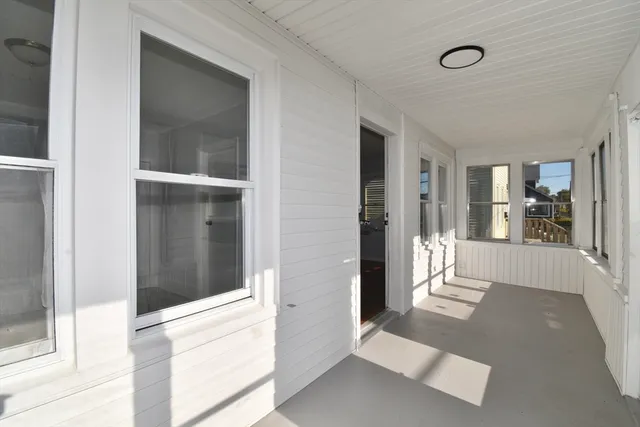 a view of a hallway with a glass door and a living room