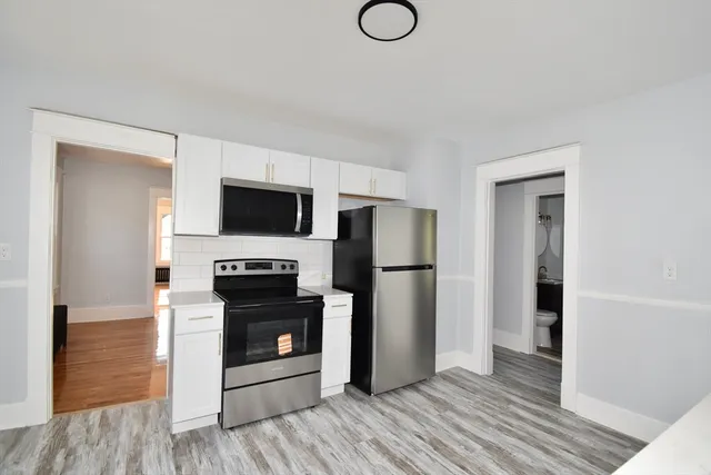 a view of a livingroom with a fireplace a flat screen tv and refrigerator
