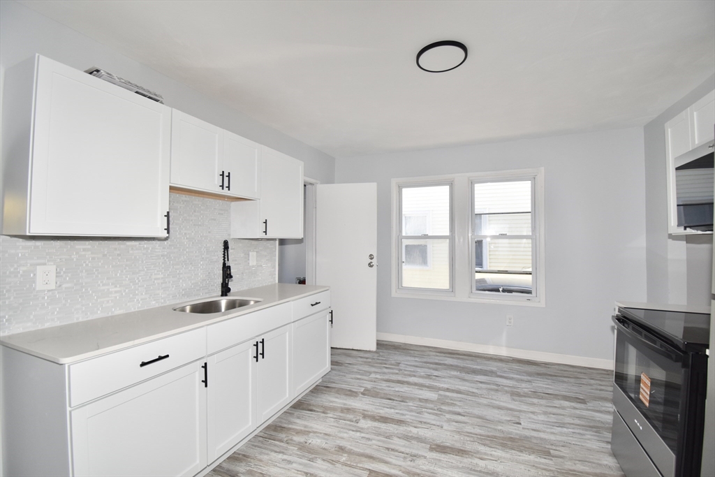 46-48 Wait Street Springfield, MA 01104 - Photo 8 of 40 a kitchen with a sink cabinets wooden floor and a window