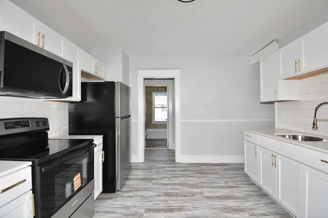 a kitchen with stainless steel appliances a stove microwave and refrigerator