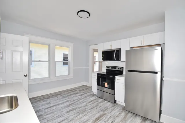 a kitchen with stainless steel appliances a refrigerator sink and microwave