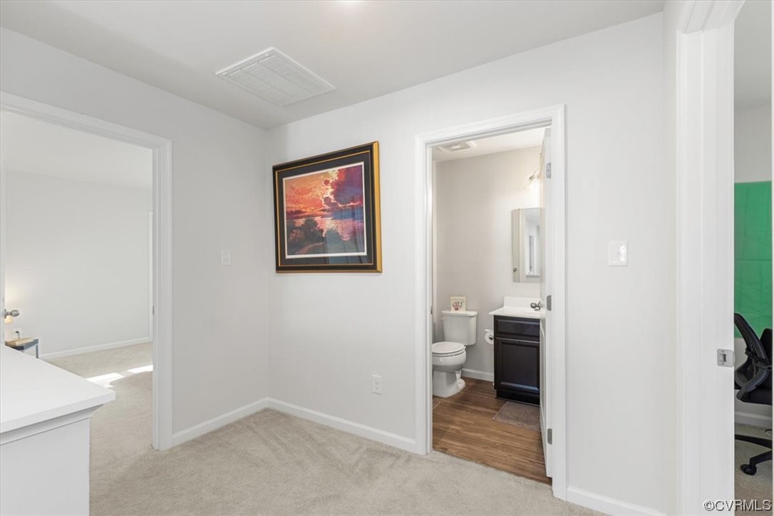 8443 Evening Star Place Richmond, VA 23235 - Photo 16 of 33 a view of a hallway with wooden floor and a bathroom